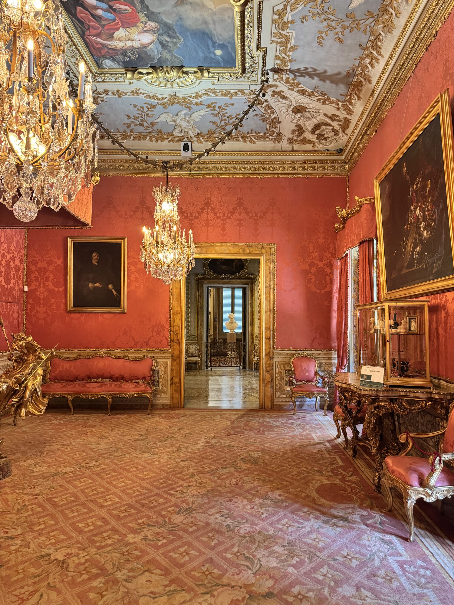 A crimson damask room at the Galleria Doria Pamphilj, gilt frames and chandeliers
